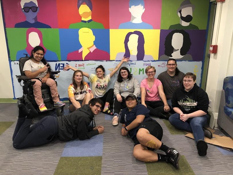 Group of students in front of painted mural in QTRAC